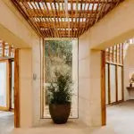 Contemporary space with stone walls, bamboo ceiling, lush potted plants—immersive Peninsula Hot Springs 1 Day spa atmosphere.