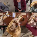 Aerial view of six people enjoying cheese and crackers during a 1 Day Hunter Valley Wine Tour, showcasing winery dining experience.