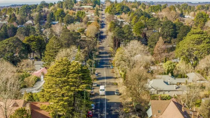 A peaceful, tree-lined suburban street extends into the distance, offering tranquillity reminiscent of a Blue Mountains sunset tour.
