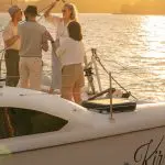 Group of friends toasting drinks at sunset on Kirralee catamaran cruise, Sydney Harbour, BYO Sparkle tour, stunning city views.