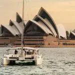 Experience a stunning BYO Sunset Sparkle Cruise on Sydney Harbour, with a catamaran sailing past the iconic Opera House at golden hour.