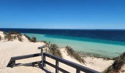a view point overlooking a white sand beach and clear waters
