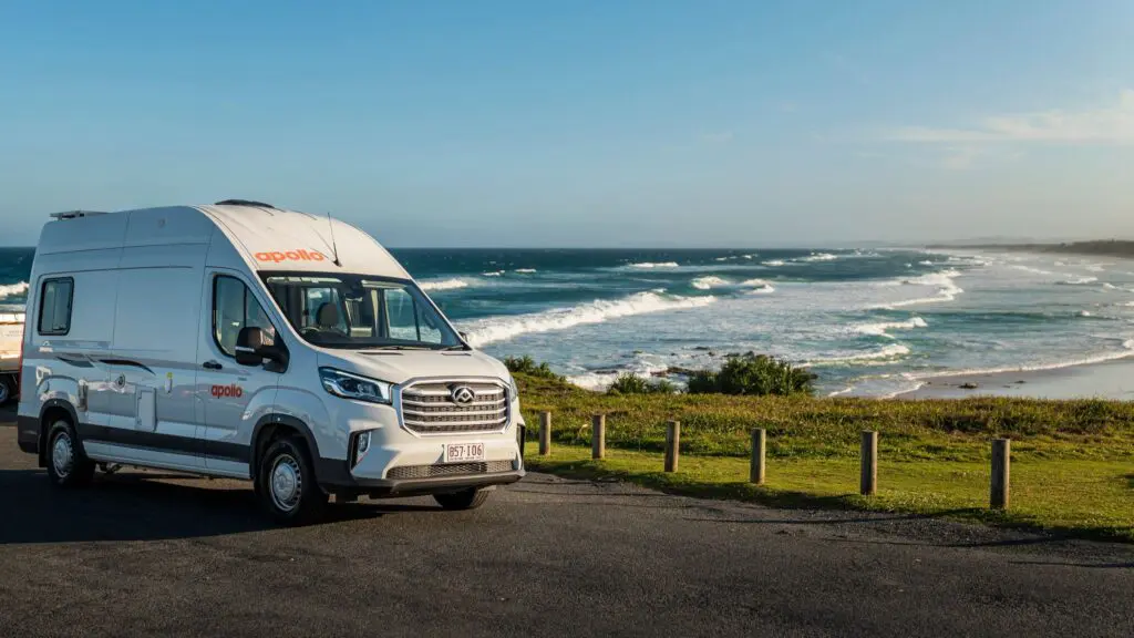 Hitop Apollo Rentals Campervan parked on the road in front of a scenic ocean pass
