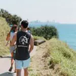 a group of people walking along a path on a cliff edge