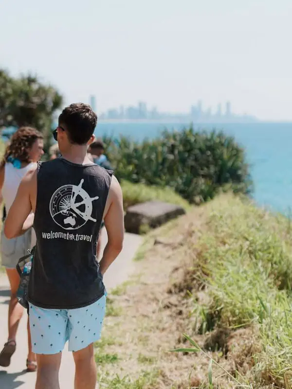 a group of people walking along a path on a cliff edge