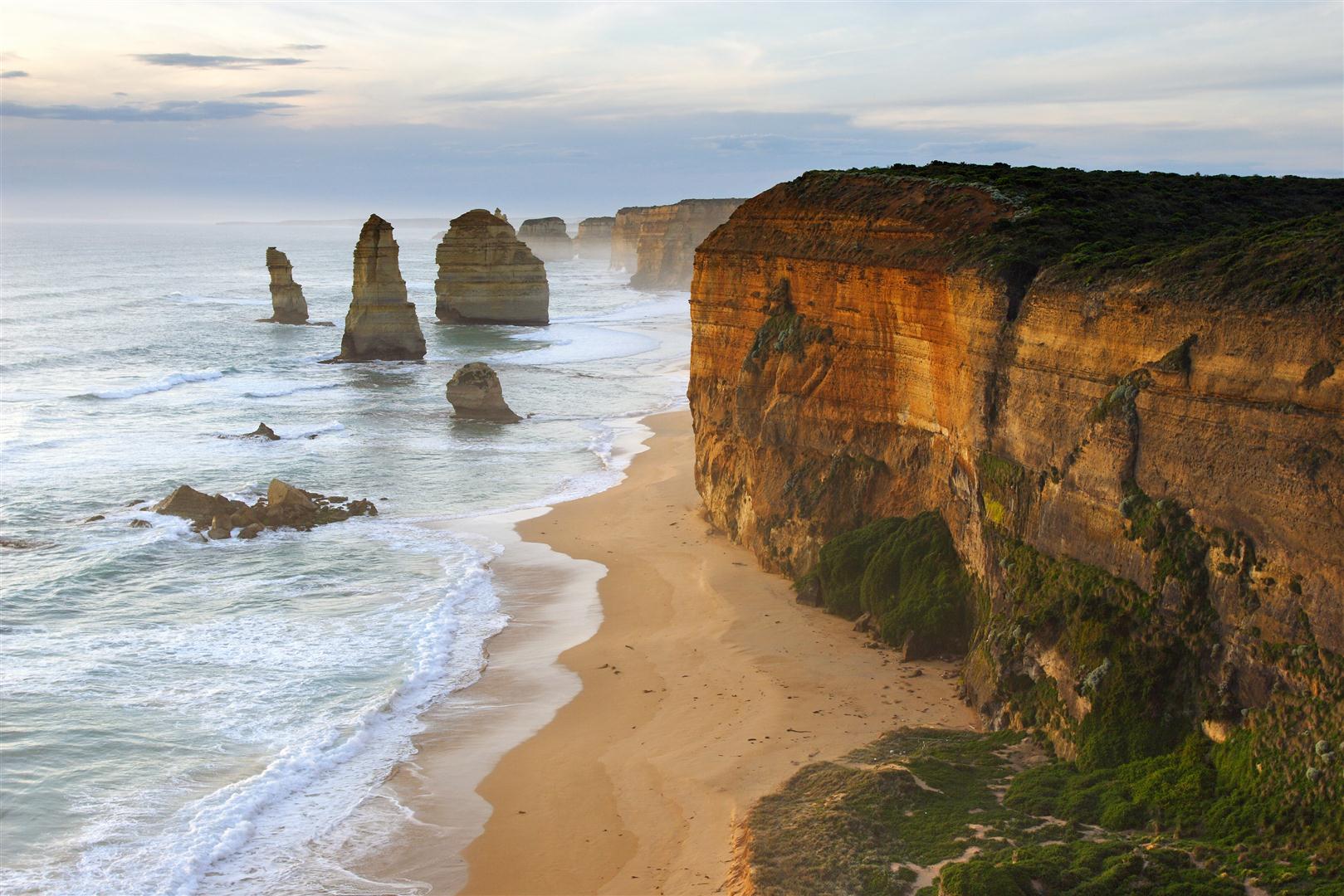 Spectacular sunset illuminates the Twelve Apostles’ iconic sea stacks and rugged cliffs on a Go West Tours Great Ocean Road day trip.