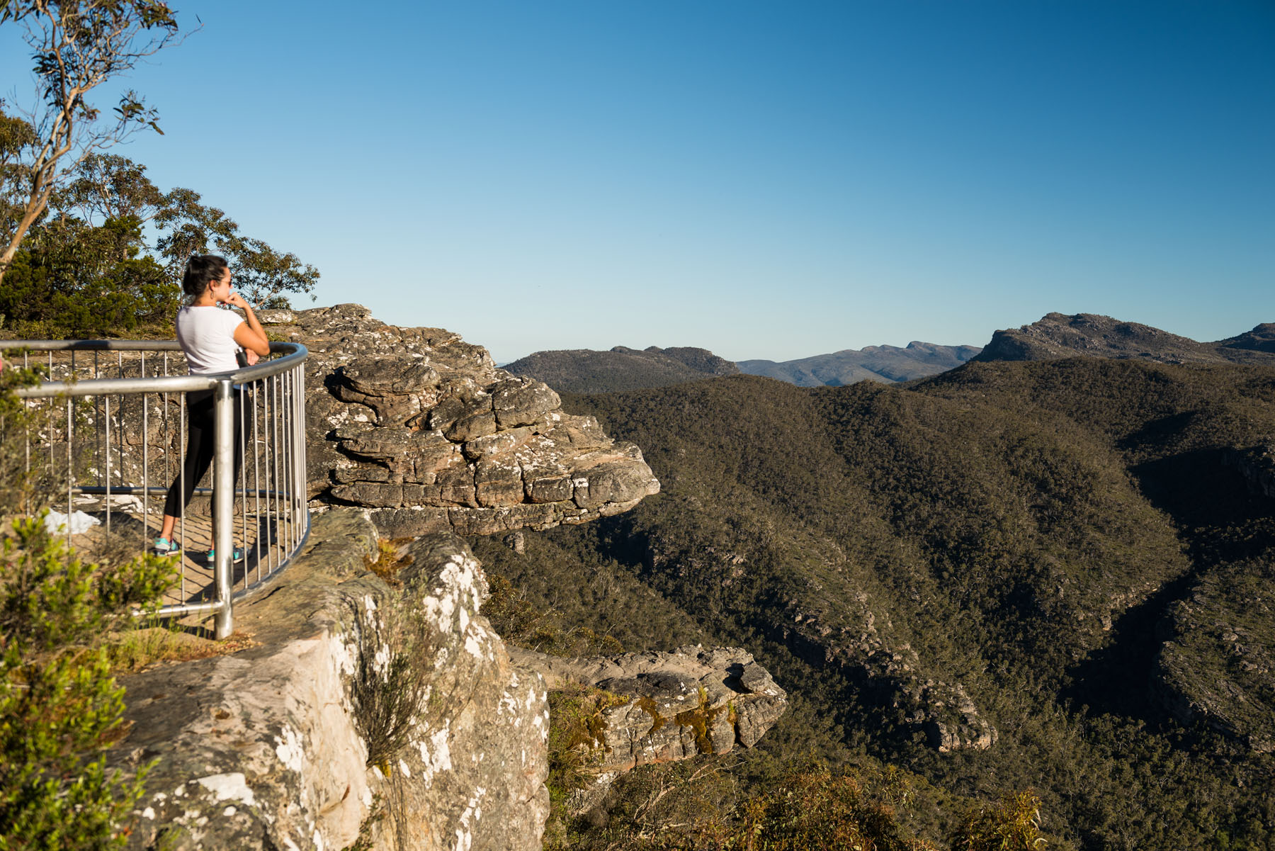 Woman enjoys breathtaking views of Grampians peaks from scenic lookout during a 1 Day Grampians Eco Wilderness Escape tour.