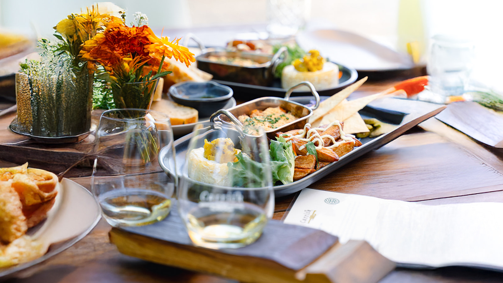 Elegant table featuring gourmet appetisers, artisan bread, fine wine glasses, and fresh flowers at a luxury boutique wine tasting tour.