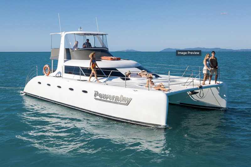 a luxury catamaran in the ocean with people sitting at the front