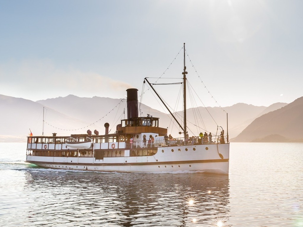 Vintage steamship cruising a serene lake with scenic mountains in the background—ideal setting for top-rated classic wine tour cruises.