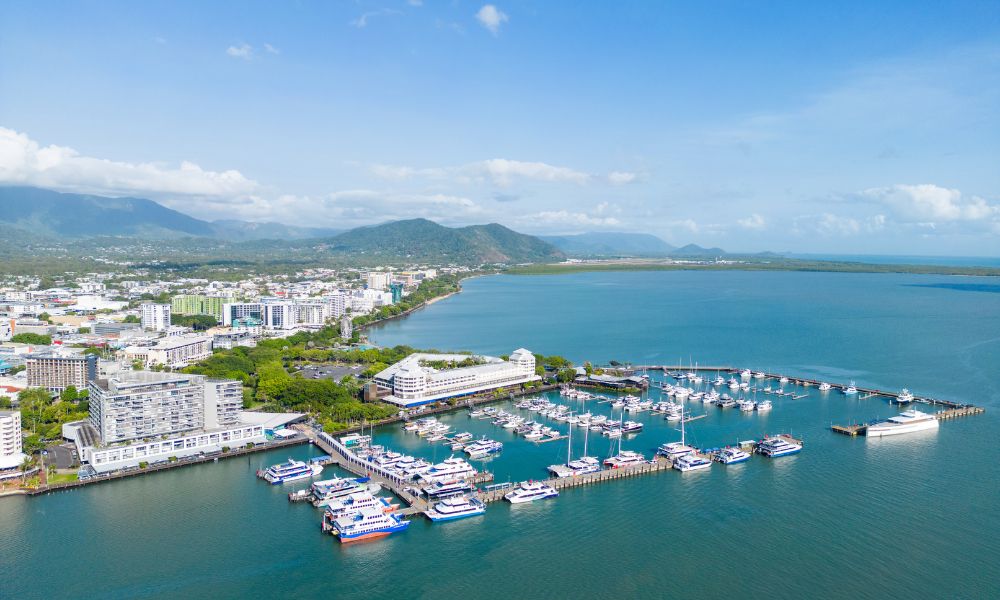 Stunning aerial view of Cairns marina with yachts, city skyline, ideal for City Sights tours or Dinner Cruise with Palm Cove Pick-up.